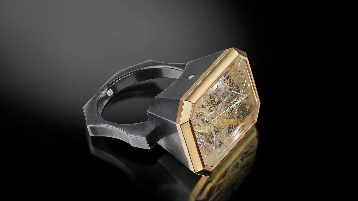 large rutilated emerald cut quartz ring in blackened sterling silver with 18Karat yellow gold bezel rim setting and two small accent diamonds
